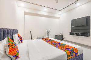 1 dormitorio con 1 cama y TV de pantalla plana en FabHotel Silver Stone Inn en Lucknow