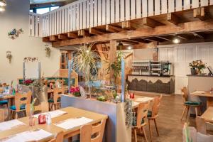 un ristorante con tavoli e sedie in legno di Hotel Thüringenschanze a Oberhof