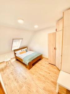 1 dormitorio con 1 cama y suelo de madera en Lemon Premium Apartment, en Szeged