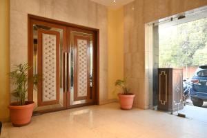 a front door with two potted plants in front of it at Regency Square Hotel in Gwalior