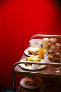 uma mesa com pratos de comida numa parede vermelha em Hotel Babula am Augarten em Viena
