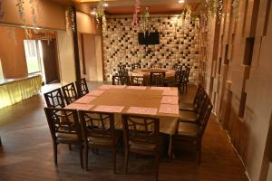 a dining room with tables and chairs and a brick wall at Regency Square Hotel in Gwalior