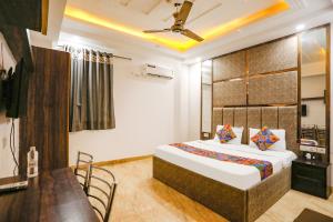 um quarto com uma cama, uma mesa e cadeiras em FabHotel Royal Mirage I em Nova Deli