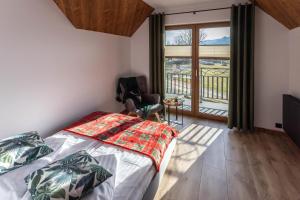 a bedroom with a bed and a large window at Dychnijzese in Czarna Góra