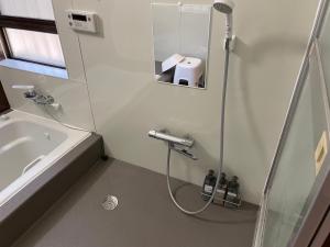 Un baño con ducha, lavabo y bañera. en Nikko Forest House, en Nikko 53 fotos más