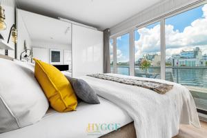 奥尔本尼兹Schwimmendes Haus Hygge Olpenitz的一间卧室，有一张带黄色枕头的床和一扇窗户