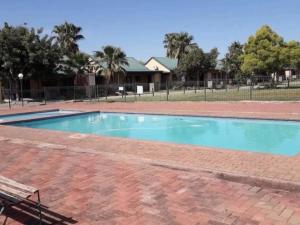 an empty swimming pool with a bench in a park at 86 Pendleberry Holiday Grove in Warmbaths