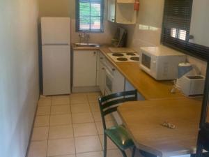 a small kitchen with a table and a white refrigerator at 86 Pendleberry Holiday Grove in Warmbaths