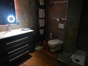 ein Bad mit einem Waschbecken, einem WC und einer Lampe in der Unterkunft Pension Pulvermühle in Waischenfeld