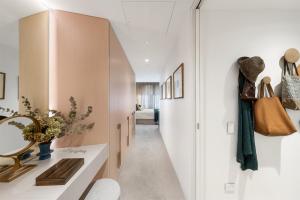 a hallway with white walls and a hallway with a white table at HARR85TR - Harrington on the Harbour in Sydney