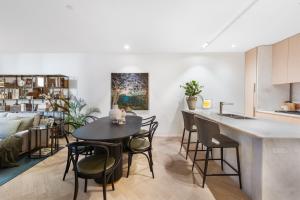 una cucina e un soggiorno con tavolo e sedie di HARR85TR - Harrington on the Harbour a Sydney