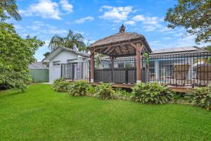 a gazebo with two chairs in a yard at Chic Miami 4BR Retreat with Swimming Pool & BBQ in Gold Coast