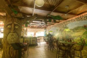 un restaurante con un árbol pintado en la pared en Adventure Inn, en San José