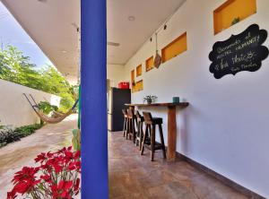 a restaurant with a counter and stools in a room at Hostel Humanity in Puerto Morelos