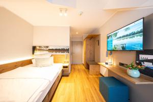 um quarto de hotel com uma cama e uma televisão de ecrã plano em Sopherl am See em Weßling