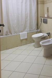 a bathroom with a toilet and a sink and a tub at West Zone Pearl Hotel Apartment in Dubai