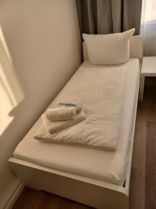a small bed in a room with two towels on it at CITYLIFE Apartments Economy Osnabrück in Osnabrück