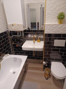 a bathroom with a white sink and a toilet at CITYLIFE Apartments Economy Osnabrück in Osnabrück