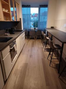 cocina con armarios blancos, mesa y sillas en CITYLIFE Apartments Economy Osnabrück en Osnabrück