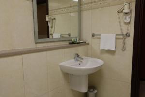 uma casa de banho com um lavatório e um espelho em West Zone Pearl Hotel Apartment no Dubai