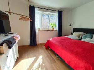 a bedroom with a red bed and a window at Haus Grünfels ApARTment in Murau