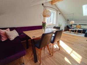 a living room with a table and a purple couch at Haus Grünfels ApARTment in Murau