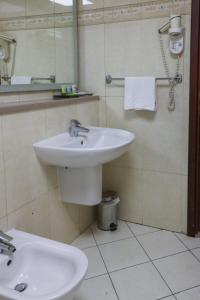 bagno con lavandino bianco e specchio di West Zone Pearl Hotel Apartment a Dubai