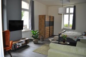 sala de estar con sofá y TV en ElisaBett Erfurt - Eine Wohnung bis 6 Personen - 4 Schlafzimmer und 2 Bäder, en Erfurt