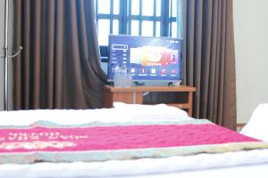 een slaapkamer met een bed en een tv op een tafel bij Biển Hải Tiến - Nhà nghỉ Ngân Khánh in Thanh Hóa