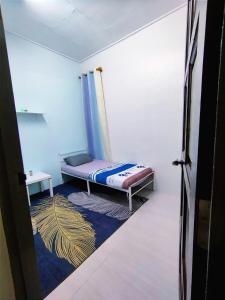 a small bedroom with a bed and a rug at Sofea guest house kemaman in Cukai
