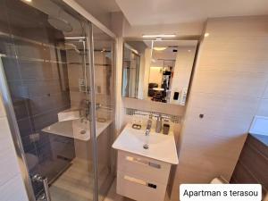 un bagno con doccia, lavandino e specchio di Dům Tamara a Luhačovice