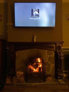 a television above a fireplace with a television above it at Brads Place - Central Ballymena close to everything in Ballymena +14 photos