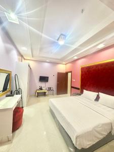 a bedroom with a large white bed and a television at Golden Quba 1 in Riyadh