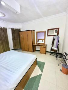 1 dormitorio con cama, escritorio y silla en Golden Quba 1, en Riad