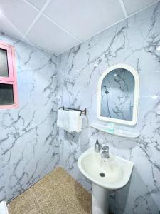 a bathroom with a white sink and a mirror at Golden Quba 1 in Riyadh