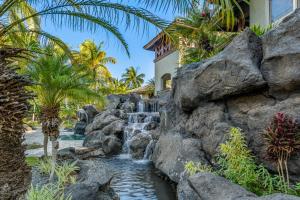 una cascada en un resort con palmeras en Mauna Lani Fairways #204, en Waikoloa