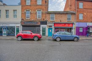 two cars parked on a street in front of buildings at Immaculate City Centre - HPC links - 5 - Parking By Hinkley Homes Short Lets & Serviced Accommodation in Bridgwater