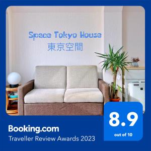 - un canapé dans un salon avec les mots Space tokyo dans l'établissement スペース東京Hostel, à Tokyo