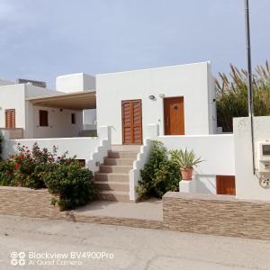 uma casa branca com escadas e plantas em Margaritis Apartments 2 em Agia Anna (Naxos)