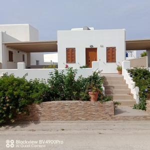 uma casa branca com escadas em frente em Margaritis Apartments 2 em Agia Anna (Naxos)