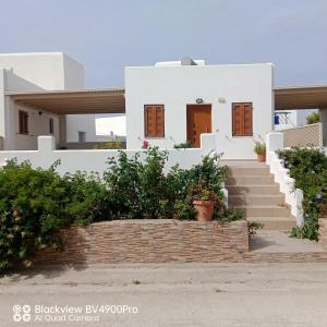Una casa blanca con escaleras al frente. en Margaritis Apartments 2, en Agia Anna de Naxos