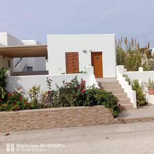 uma casa branca com uma escada e flores em Margaritis Apartments 2 em Agia Anna (Naxos)