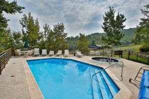 a large swimming pool with chairs and a table at Snowmass Village, 2 Bedroom at Chamonix Ski-in Ski-out in Snowmass Village