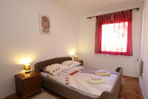 een slaapkamer met een bed met twee handdoeken erop bij Apartment Lidija in Šilo