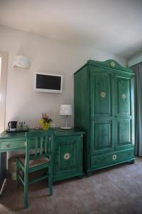 a green cabinet and a table and a desk at Le Vanille in Costa Rei