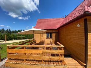 a wooden deck with a table and an umbrella at Domki Pszczółka in Krasnobród