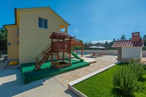 un patio trasero con un parque infantil con un tobogán en Villa Valentina Nin, en Ninski Stanovi