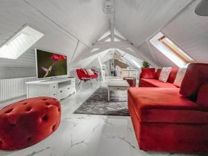 ein Wohnzimmer mit einem roten Sofa und einem TV in der Unterkunft Loft apartment in the Castle Château du Châtelard in Montreux