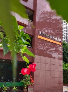 un edificio con una flor roja delante de él en The Maple Suite, en Kuala Lumpur