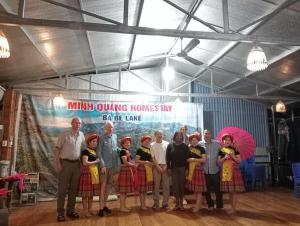 a group of people standing in front of a banner at Minh Quang homestay in Ba Be
